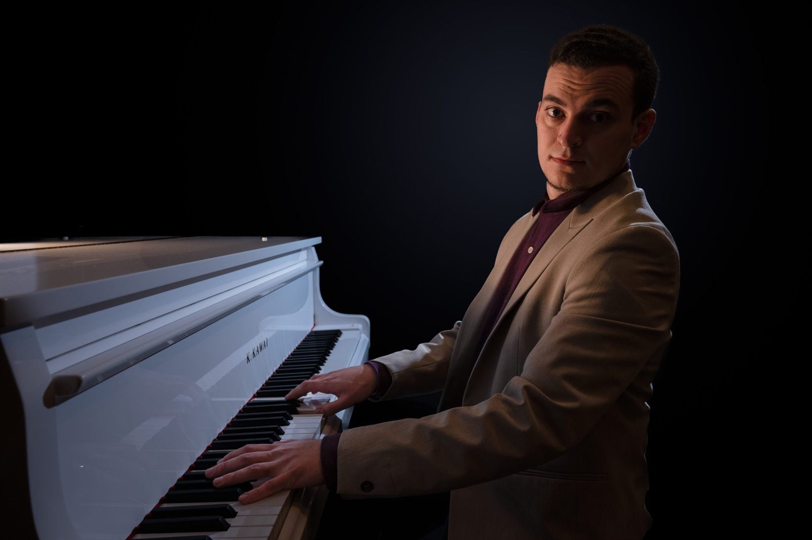 John C Buttigieg, British-Maltese composer and contemporary pianist, seated at a piano